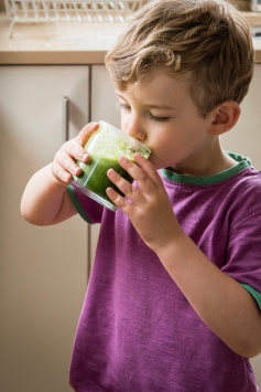 Toddler drinking green smoothie
